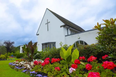 Gwent Crematorium building surrounded by bright flowers / Adeilad Amlosgfa Gwent wedi'i amgylchynu gan flodau llach.ar